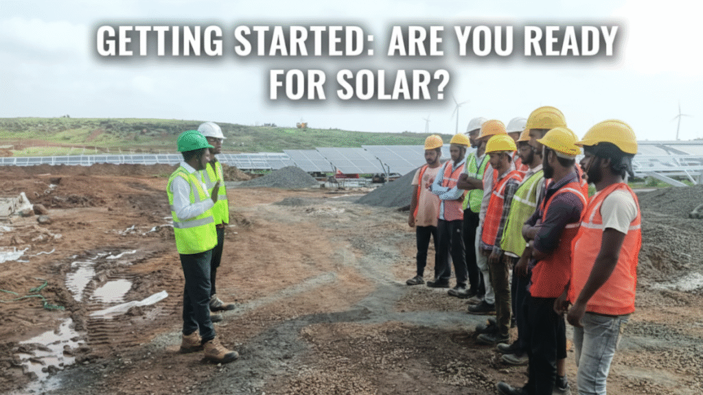 A close-up of a person's hand pointing at a solar panel on a rooftop.